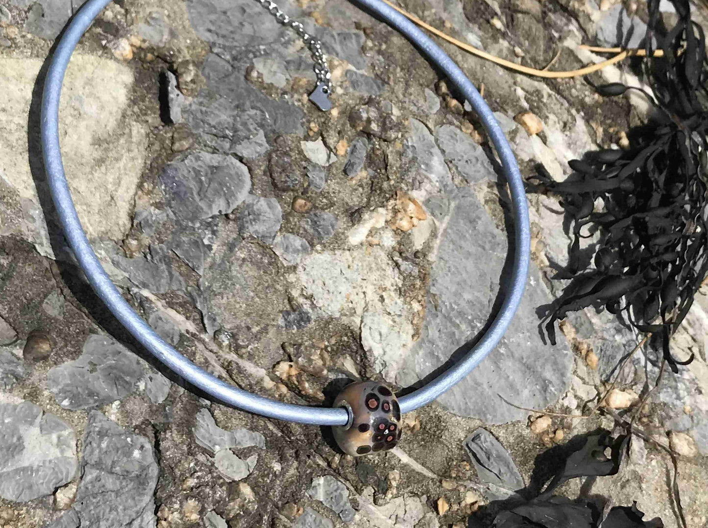 Choker necklace with off-white cylinder glass bead (Murano-style glass handmade in Montreal), black and orange dots, baby blue leather cord, stainless steel clasp