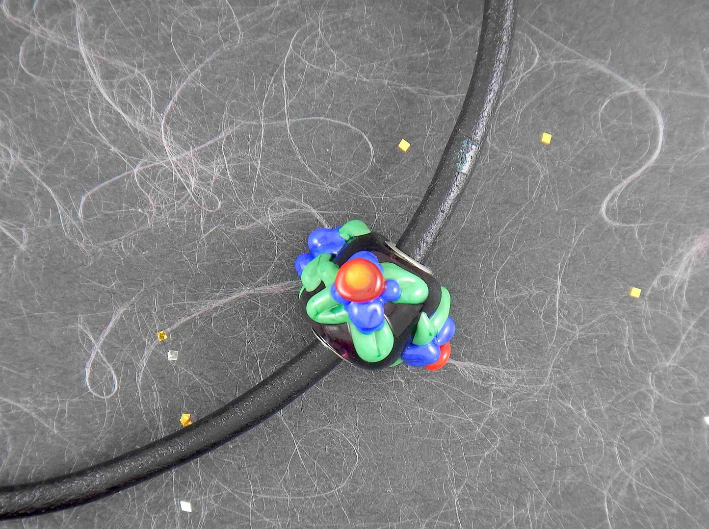 Choker necklace with black cylinder glass bead (Murano-style glass handmade in Montreal), 3-dimensional red-blue-green flowers, black leather cord, stainless steel clasp