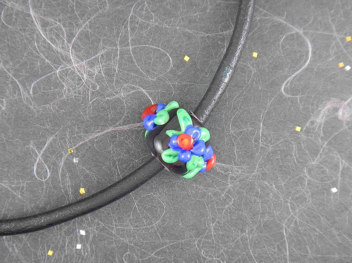 Choker necklace with black cylinder glass bead (Murano-style glass handmade in Montreal), 3-dimensional red-blue-green flowers, black leather cord, stainless steel clasp