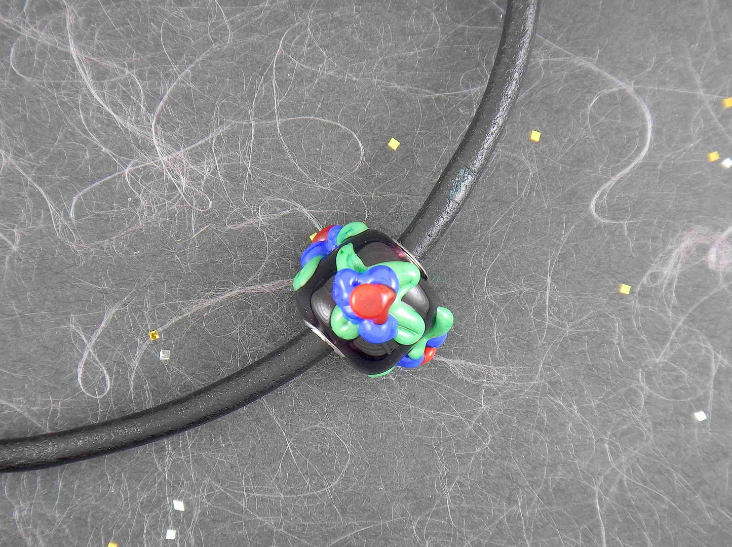 Choker necklace with black cylinder glass bead (Murano-style glass handmade in Montreal), 3-dimensional red-blue-green flowers, black leather cord, stainless steel clasp