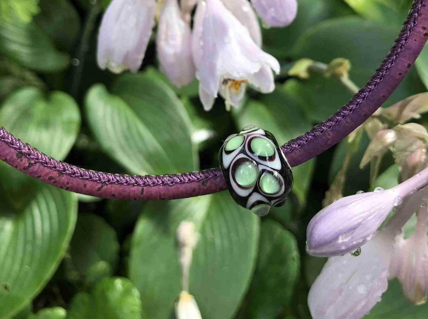 Choker necklace with deep purple cylinder glass bead (Murano-style glass handmade in Montreal), 3-dimensional white-translucent green dots, purple cork cord, stainless steel clasp
