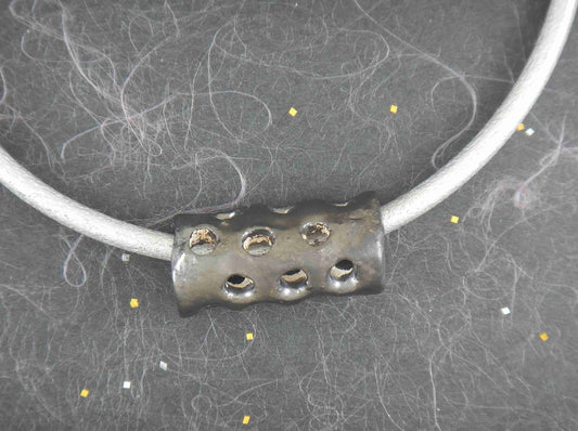 Choker necklace with black nickel ceramic cylinder handmade in Montreal, hole pattern, metallic silver leather cord, stainless steel clasp