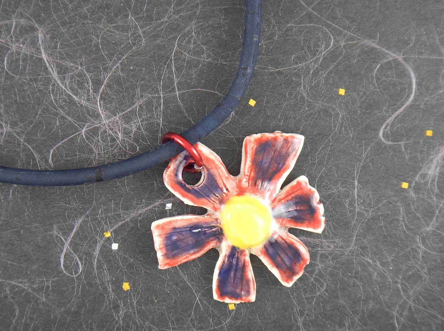 Collier 16 po à pendentif de faïence marguerite bleu-rouge-jaune fait à la main à Montréal, cordon de liège bleu foncé, anneau aluminium, fermoir acier inoxydable
