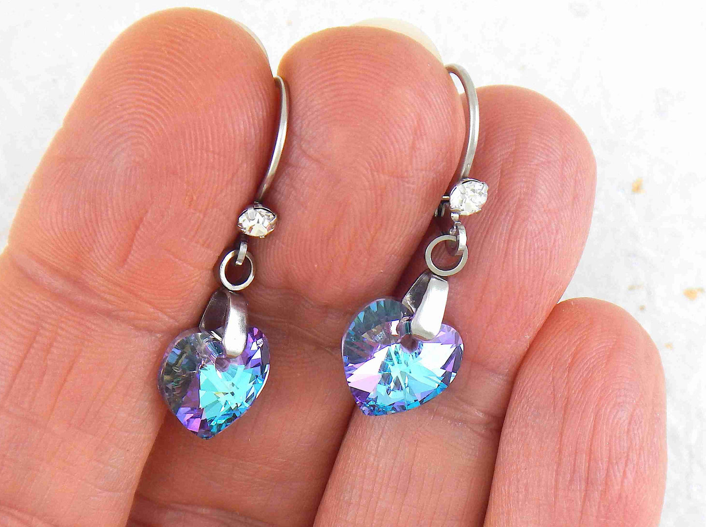 Short earrings with 10mm faceted Vitrail Light (sky blue and lilac) Swarovski crystal hearts, stainless steel lever back hooks with tiny clear crystals
