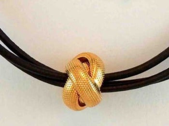 Choker necklace with vintage golden metal knot on triple black leather strands