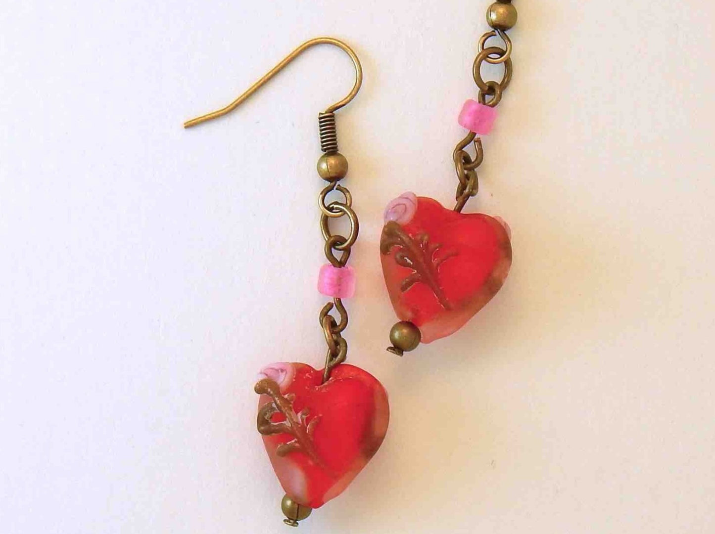 Long earrings with small frosted red glass hearts, rose details, brass hooks