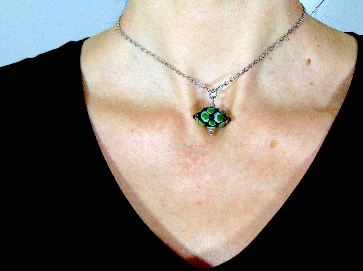 14-inch necklace with black saucer-shaped Murano glass bead, 3-dimensional green and white dots, stainless steel chain
