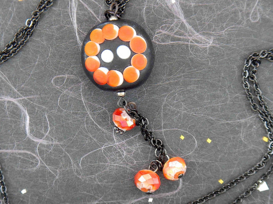24-inch necklace with black-red-white matte plump Murano glass round pendant, geometrical floral/sun pattern, black stainless steel chain