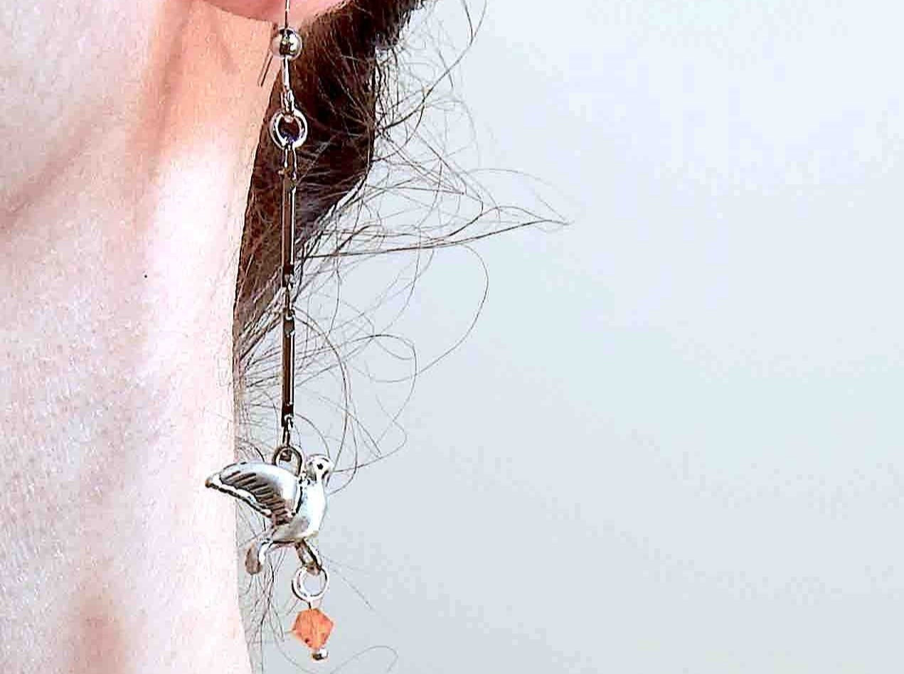 Long earrings with small pewter flying birds and orange Swarovski crystals, metal hooks