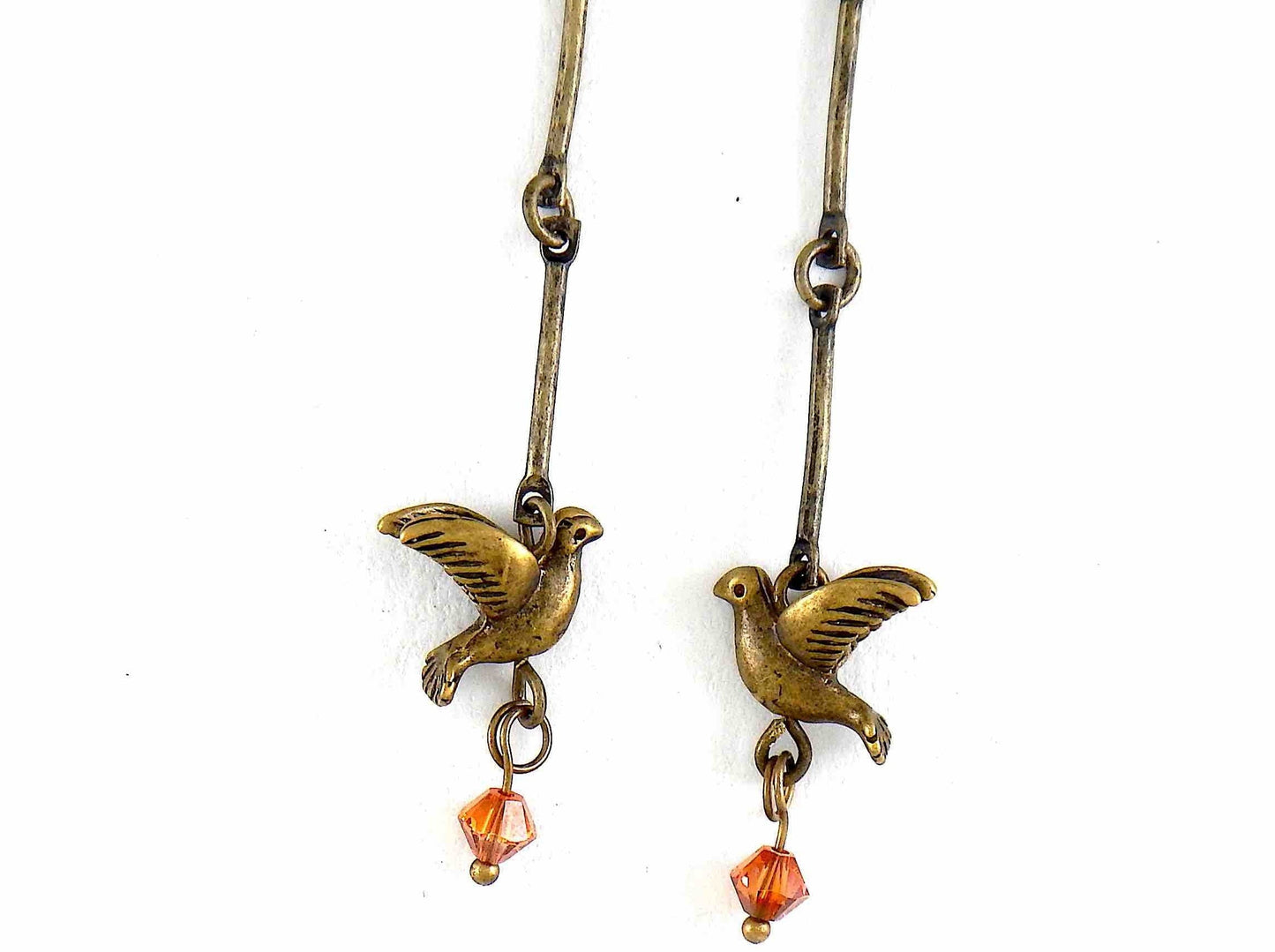 Long earrings with small brass flying birds and burnt orange Swarovski crystals, brass hooks