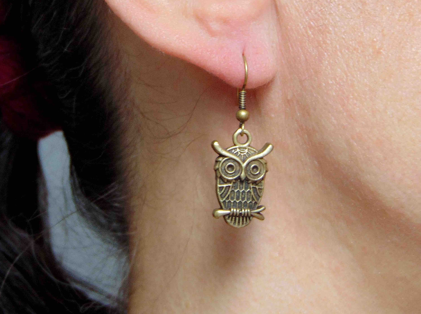 Short earrings with large brass owls sitting on a branch, brass hooks