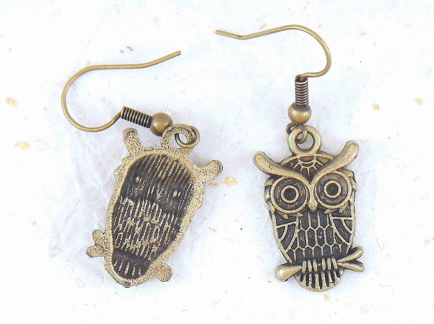 Short earrings with large brass owls sitting on a branch, brass hooks