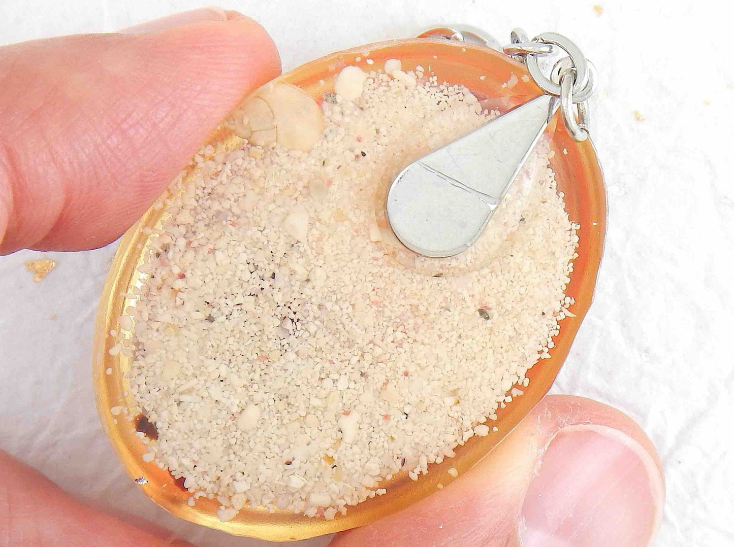 Porte-clés avec ovale de résine fait main, sable blanc, verre rouge et orange, coquillages, chaîne acier inoxydable