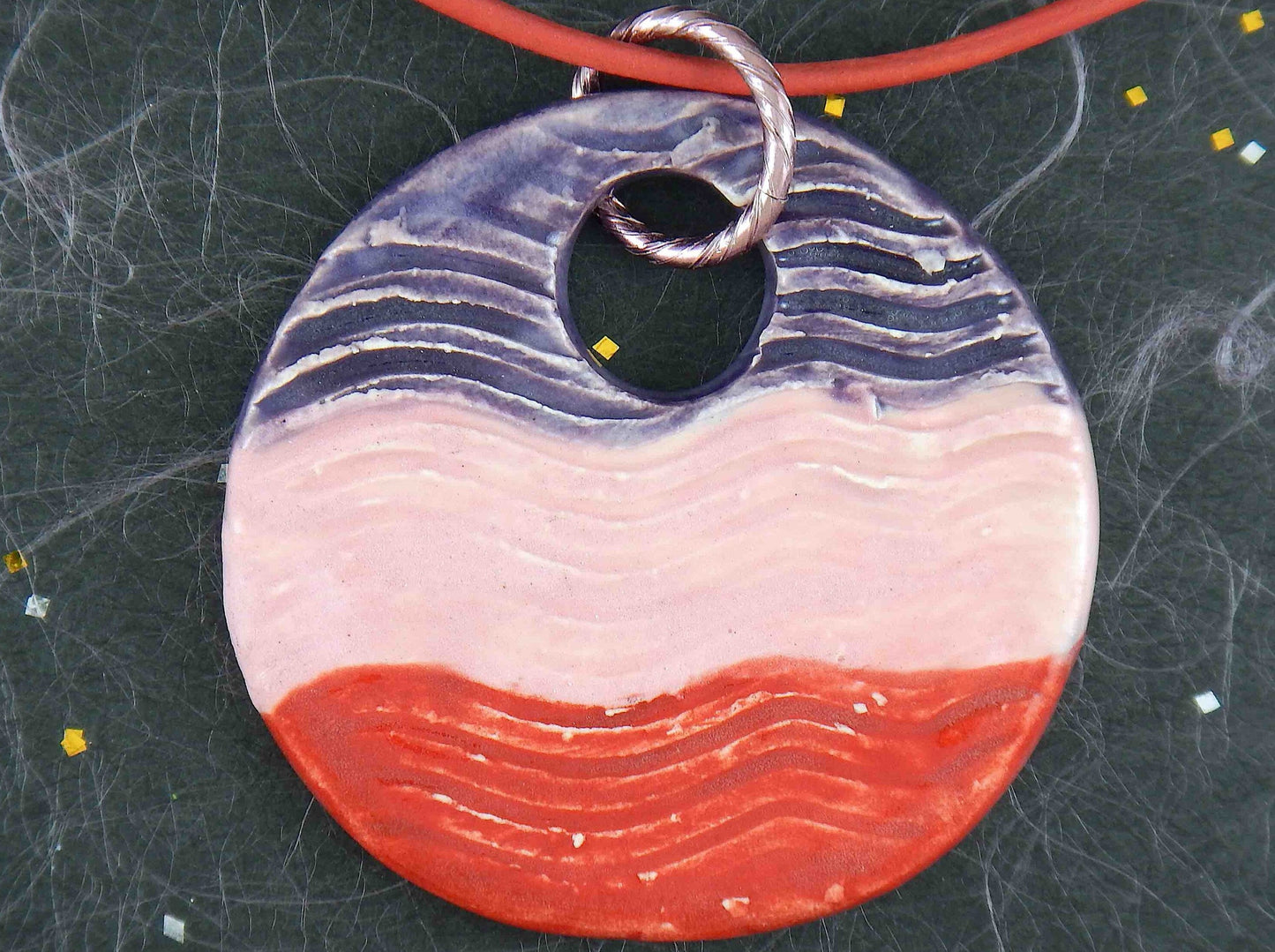Collier 16 po à grand pendentif de faïence rond vagué violet-rose-rouge fait à la main à Montréal, cordon de cuir rouge, anneau aluminium, fermoir acier inoxydable