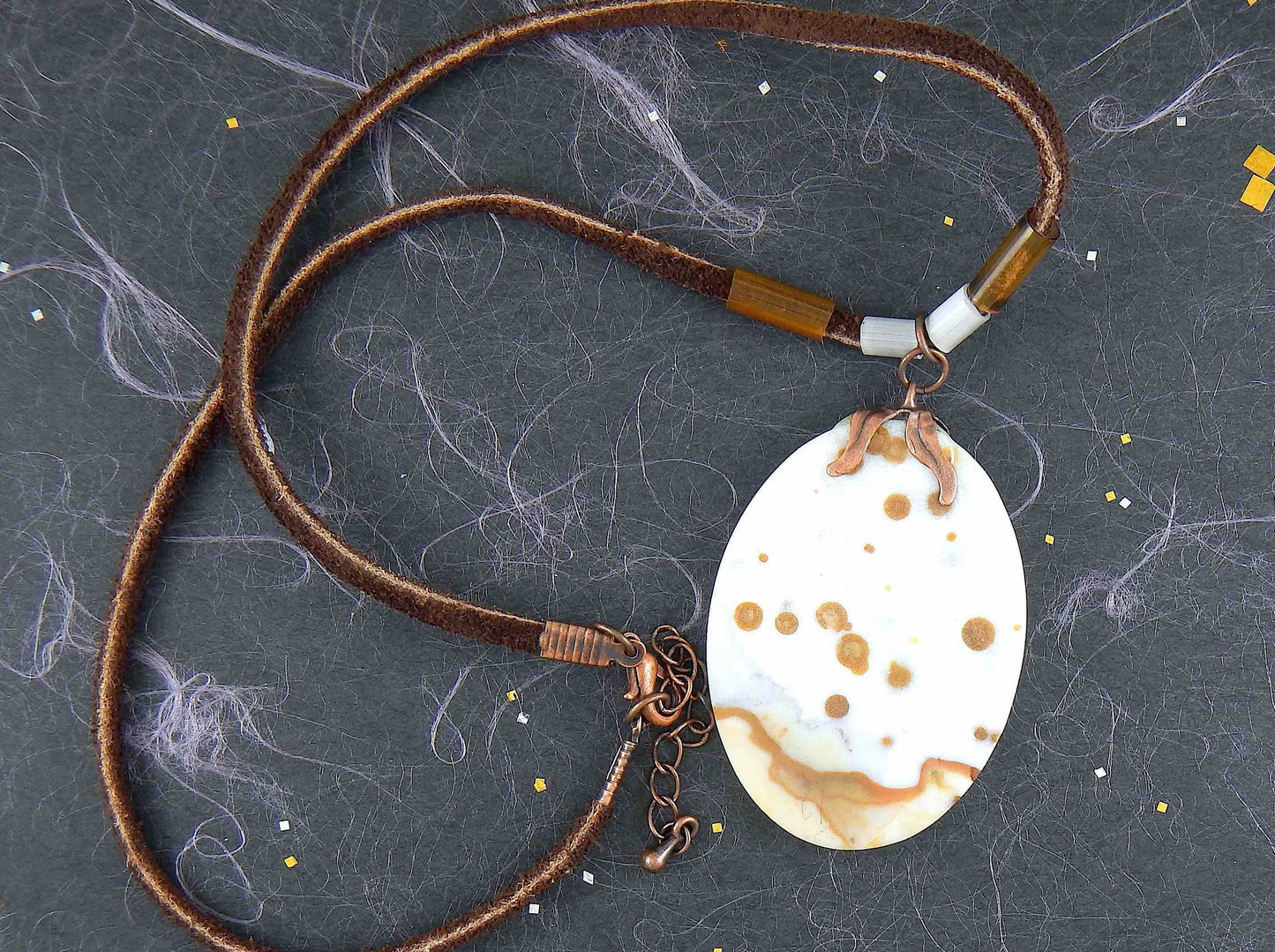 17-inch necklace with matte white and caramel jasper pendant on brown leather cord, antique glass cylinder beads, copper clasp