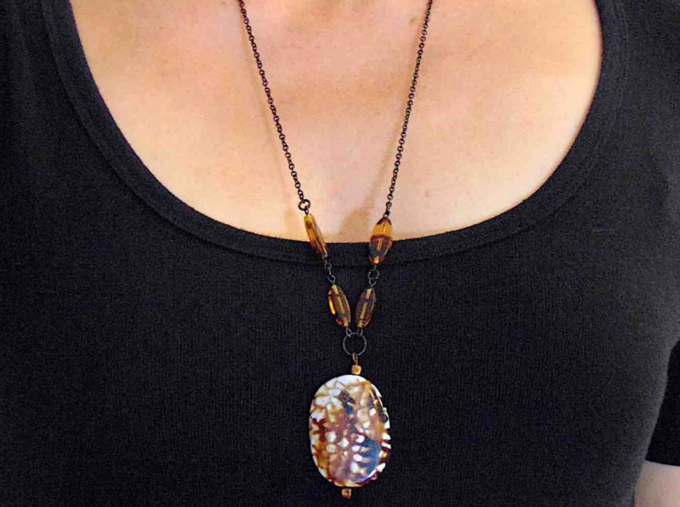 26-inch necklace with speckled black-brown-white jasper stone pendant, striped amber glass beads, black stainless steel chain