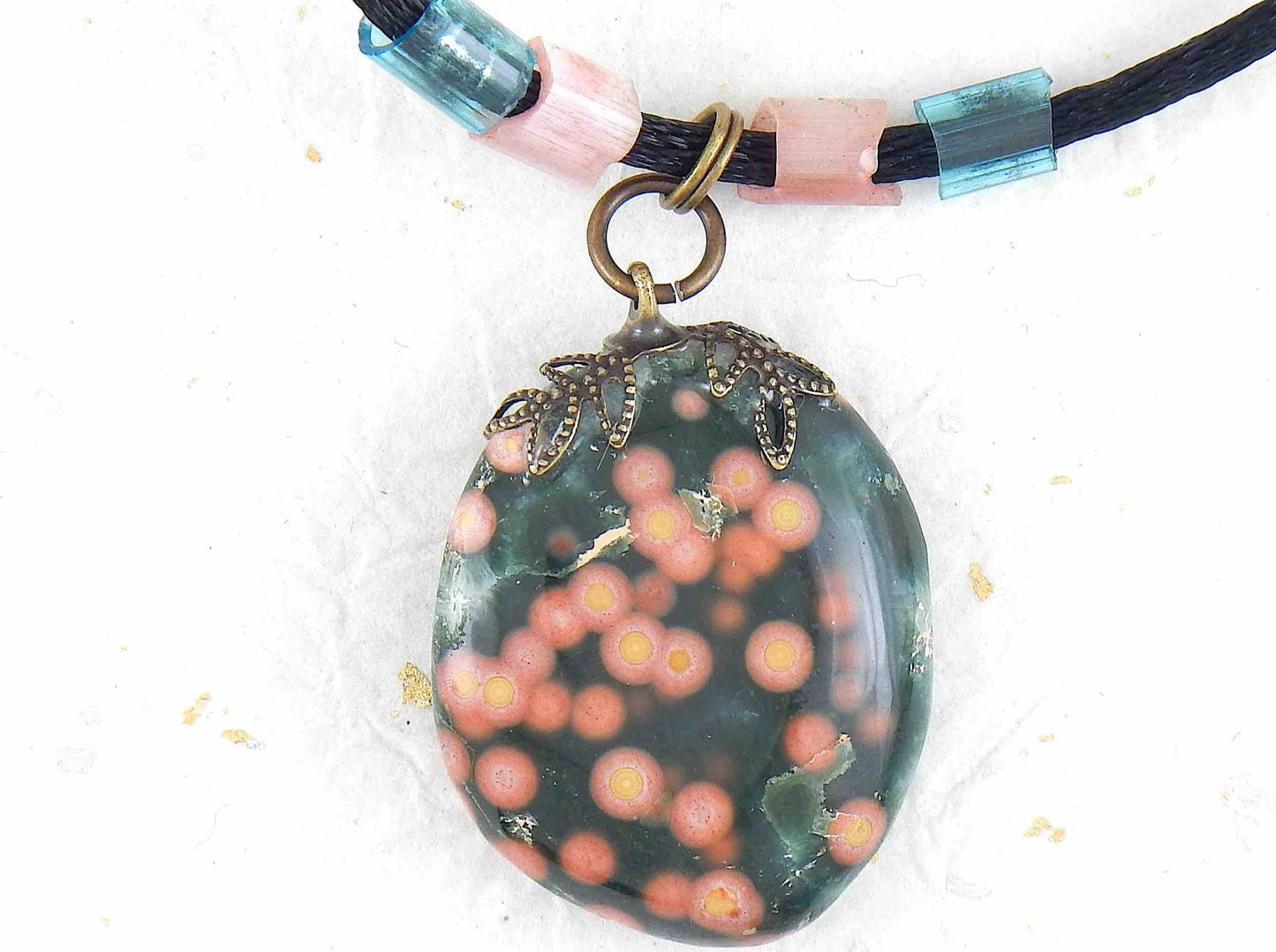 20-inch forest green oval jasper pendant with coral pink dots, black satin cord, antique glass cylinder beads, copper clasp