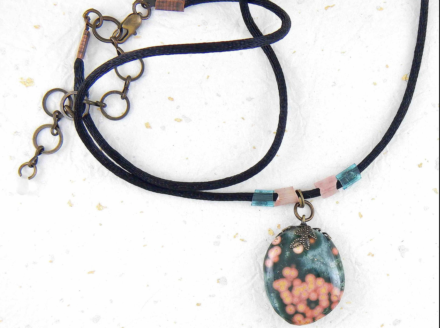 20-inch forest green oval jasper pendant with coral pink dots, black satin cord, antique glass cylinder beads, copper clasp