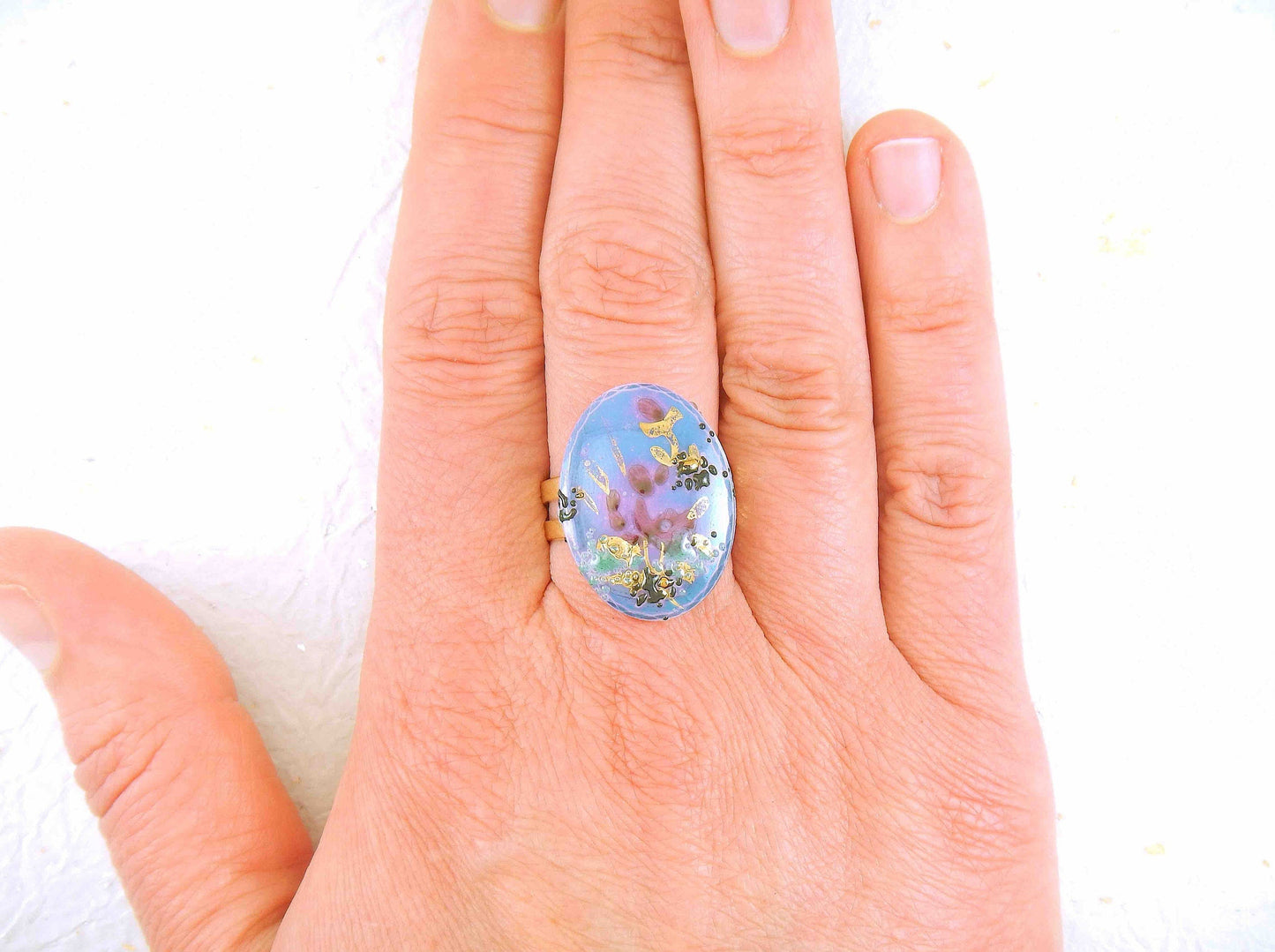 Finger ring with hand-painted blue-pink-gold-black oval vintage glass cabochon, abstract flower pattern, gold-toned stainless steel adjustable base