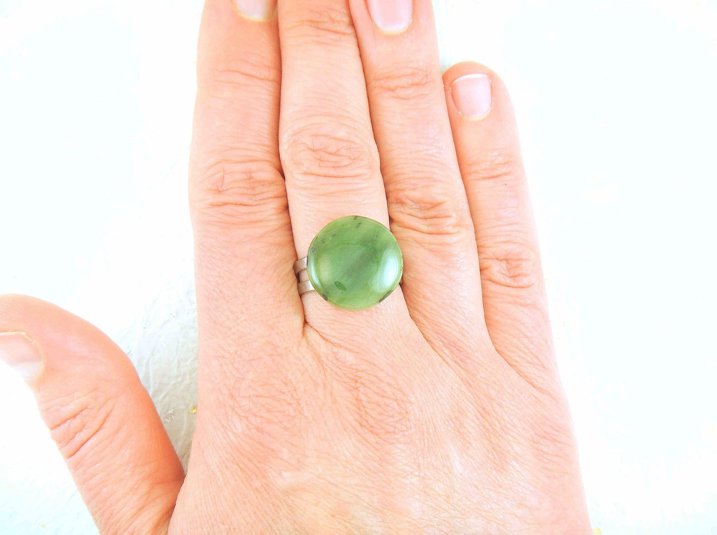 Finger ring with round dark green nephrite jade stone cabochon, stainless steel adjustable base