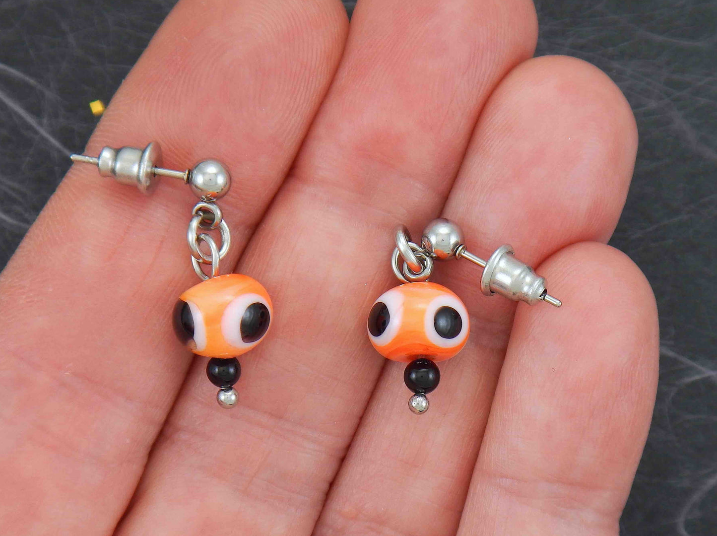 Short earrings with bright orange glass balls, black and white dots (Murano-style glass handmade in Montreal), stainless steel posts