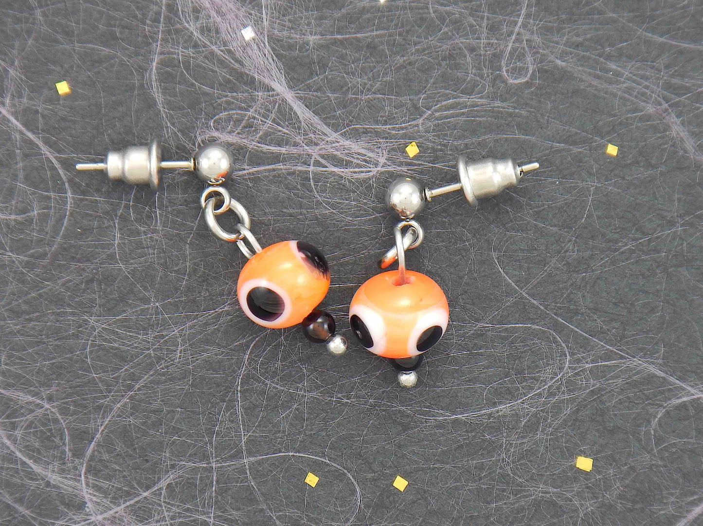 Short earrings with bright orange glass balls, black and white dots (Murano-style glass handmade in Montreal), stainless steel posts