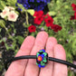 Choker necklace with black cylinder glass bead (Murano-style glass handmade in Montreal), 3-dimensional red-blue-green flowers, black leather cord, stainless steel clasp