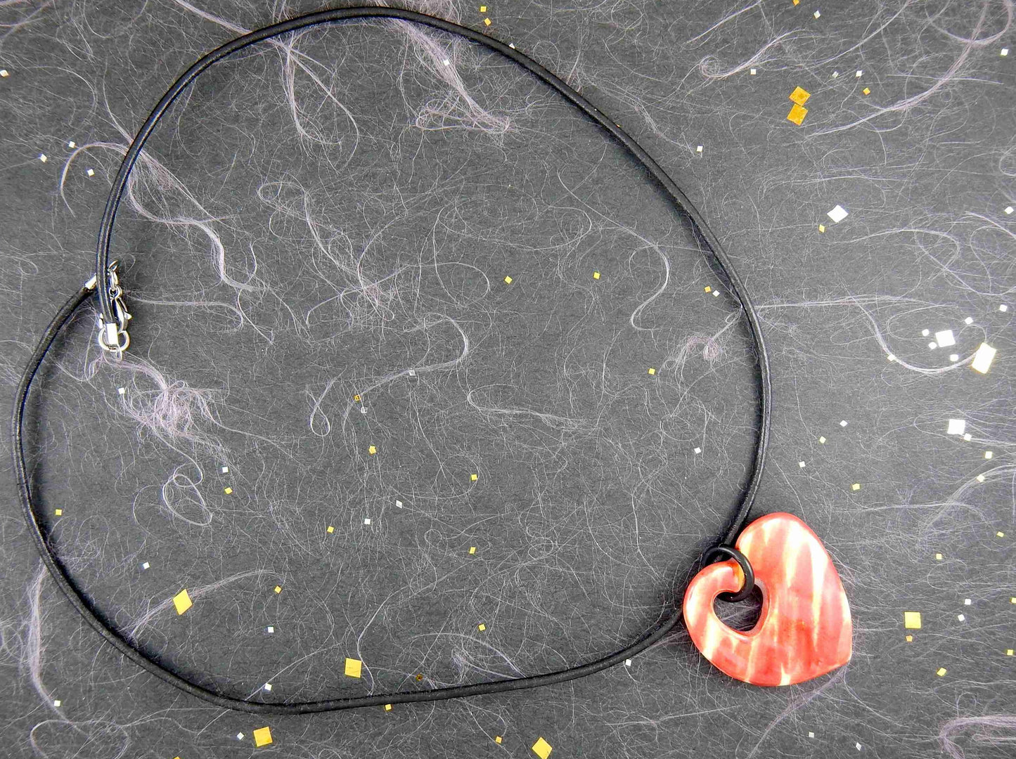 18-inch necklace with marbled red and yellow ceramic heart handmade in Montreal, heart-shaped hole, black leather cord, stainless steel clasp