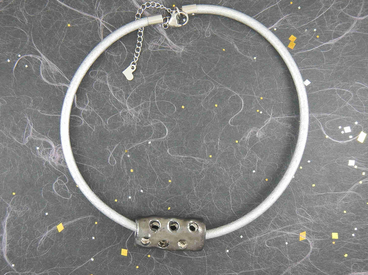 Choker necklace with black nickel ceramic cylinder handmade in Montreal, hole pattern, metallic silver leather cord, stainless steel clasp