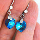 Short earrings with 10mm faceted Bermuda Blue Swarovski crystal hearts, stainless steel lever back hooks with tiny clear crystals