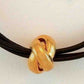 Choker necklace with vintage golden metal knot on triple black leather strands