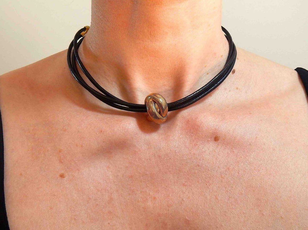 Choker necklace with vintage golden metal knot on triple black leather strands