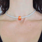 Collier tour de cou avec bille de verre orange vif (verre style Murano fait main à Montréal), inclusions de verre dichroïque, cordon de cuir blanc perlé, fermoir acier inoxydable