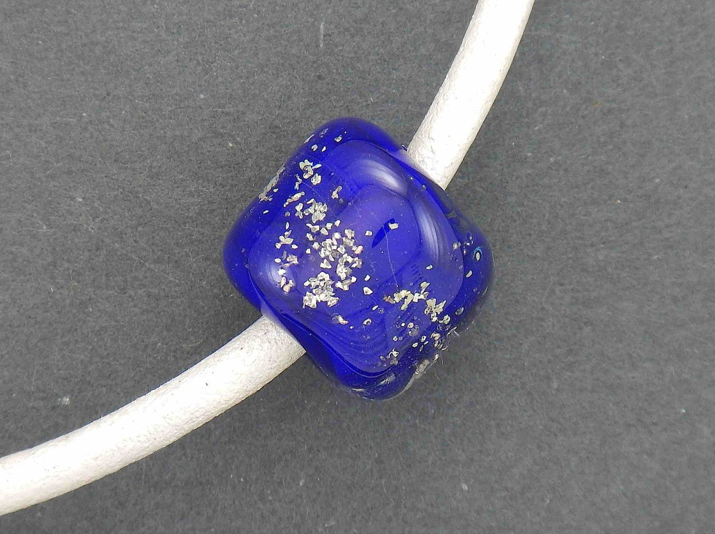 Collier tour de cou avec cylindre de verre bleu minuit (verre style Murano fait main à Montréal), inclusions d'argent véritable, cordon de cuir blanc fini perlé, fermoir acier inoxydable