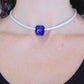 Collier tour de cou avec cylindre de verre bleu minuit (verre style Murano fait main à Montréal), inclusions d'argent véritable, cordon de cuir blanc fini perlé, fermoir acier inoxydable