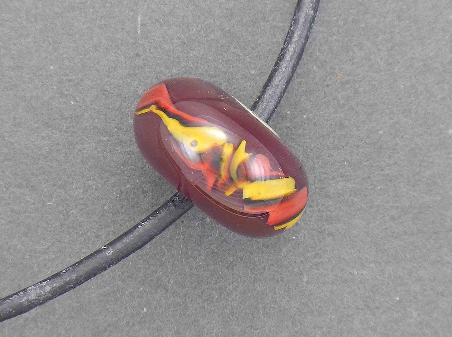 Choker necklace with burgundy red glass bead (Murano-style glass handmade in Montreal), red and yellow cane pattern, black leather cord, stainless steel clasp