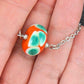 14-inch necklace with burnt orange ball, large white & green dots (Murano-style glass handmade in Montreal), stainless steel chain