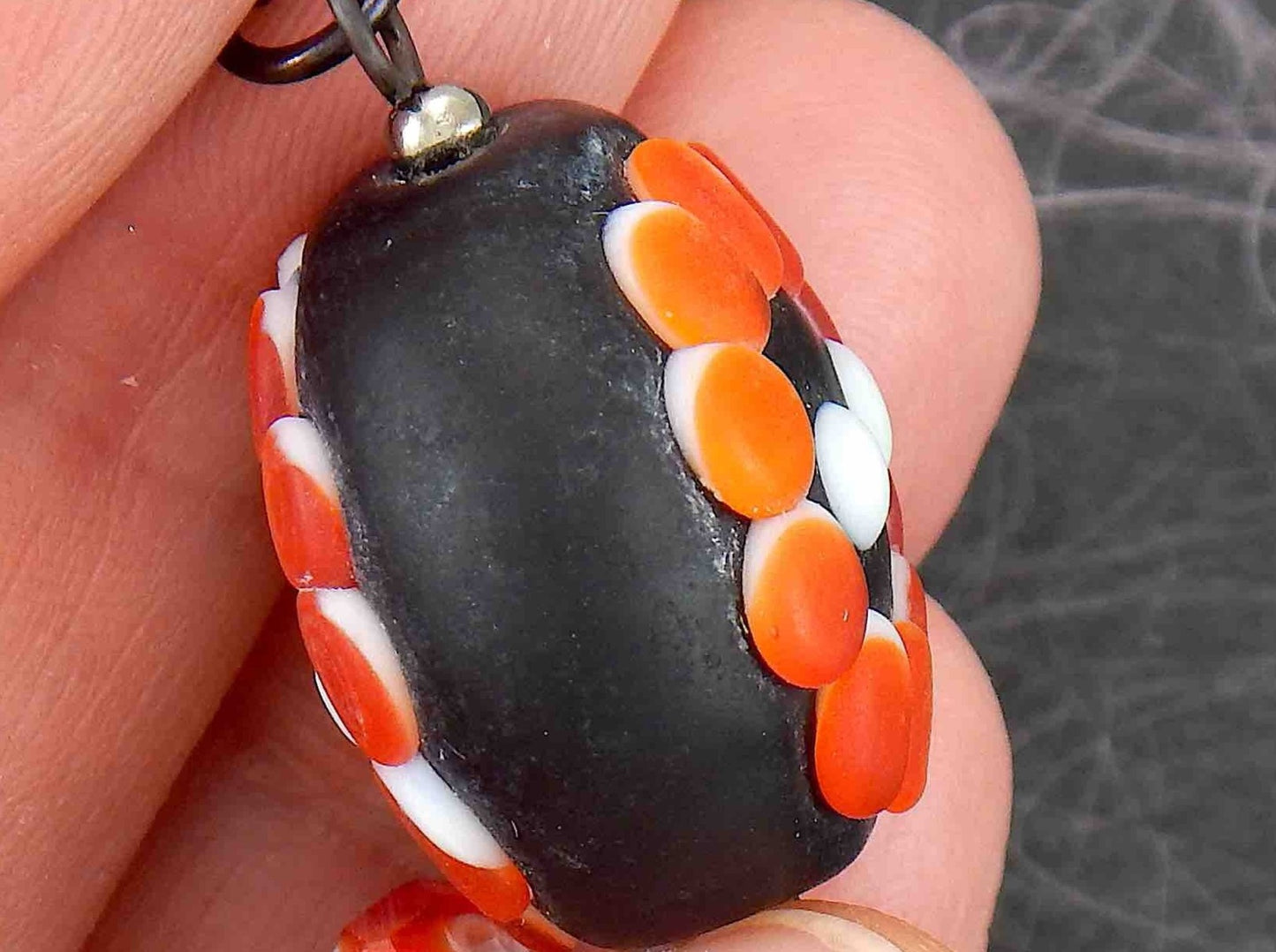 24-inch necklace with black-red-white matte plump Murano glass round pendant, geometrical floral/sun pattern, black stainless steel chain