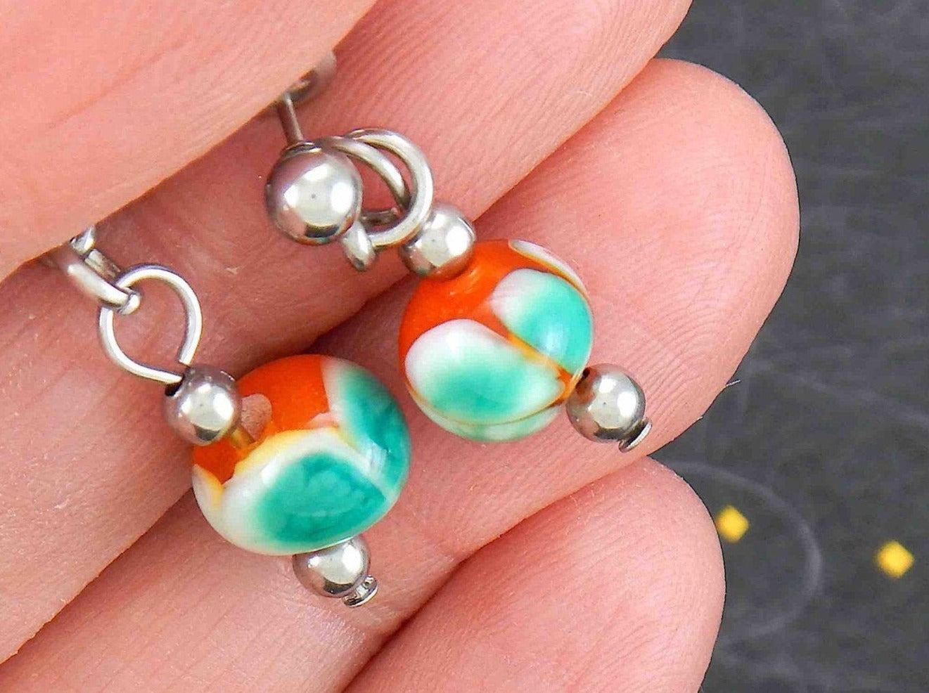 Short earrings with burnt orange glass balls, white and green dots (Murano-style glass handmade in Montreal), stainless steel posts