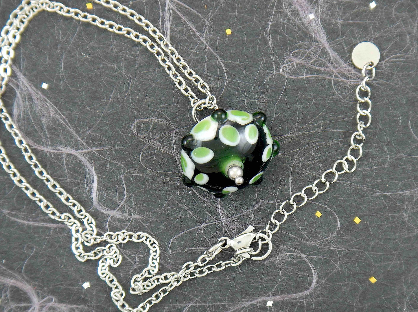 14-inch necklace with black saucer-shaped Murano glass bead, 3-dimensional green and white dots, stainless steel chain