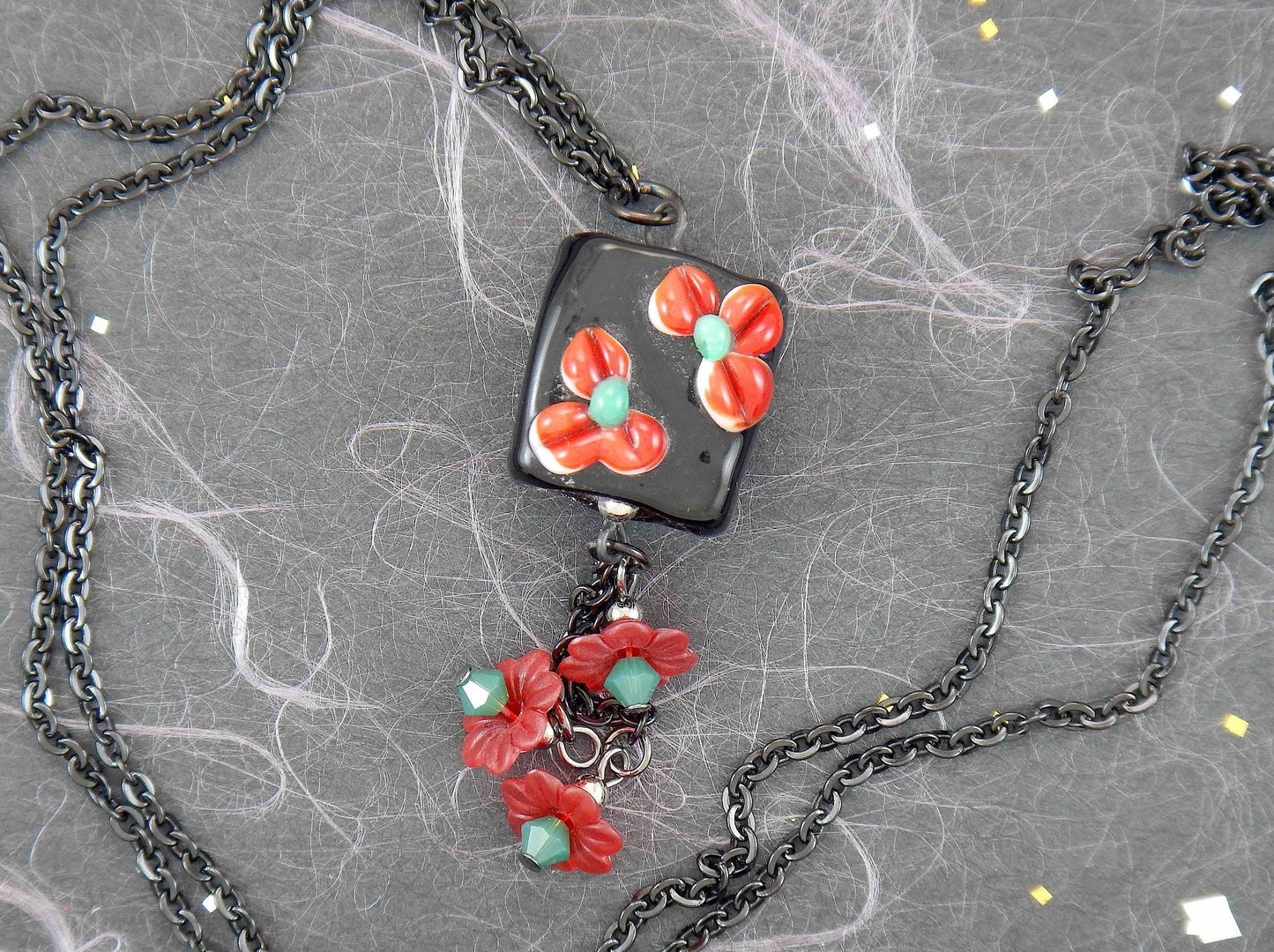 24-inch necklace with black Murano glass square, red-green 3D flowers, pendants with vintage lucite flowers and green Swarovski crystals, black stainless steel chain