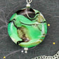 29-inch necklace with Murano glass round pendant marbled in bright apple green, black and white, stainless steel chain