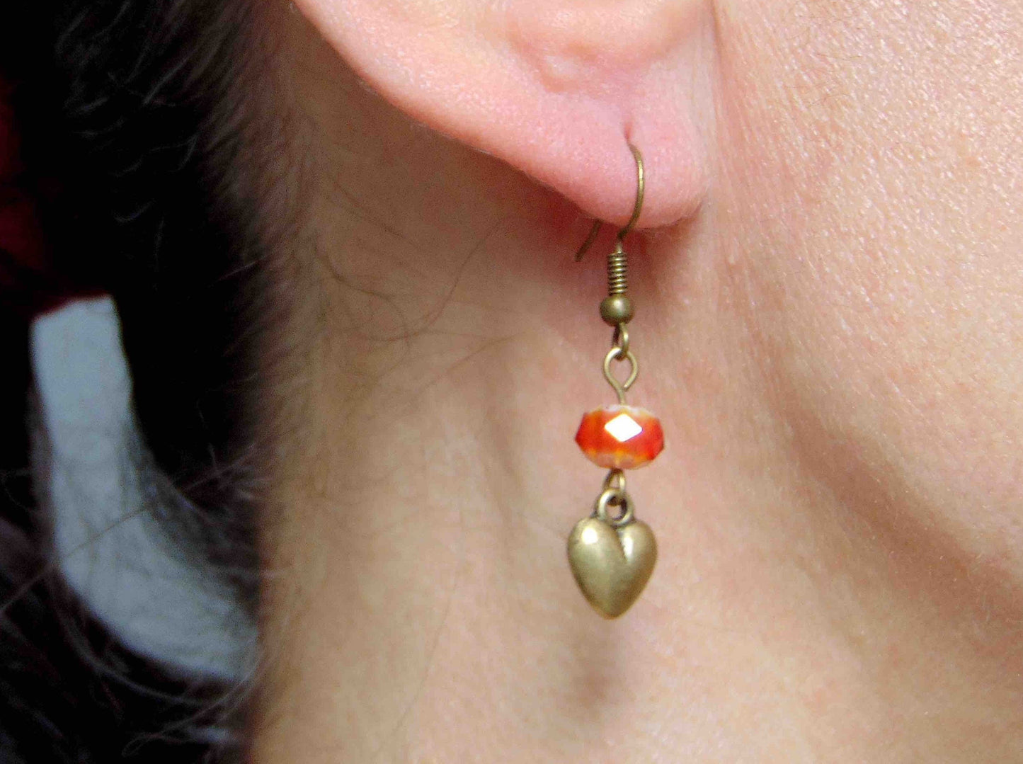 Long earrings with plump brass hearts and iridescent red faceted crystal balls, brass hooks