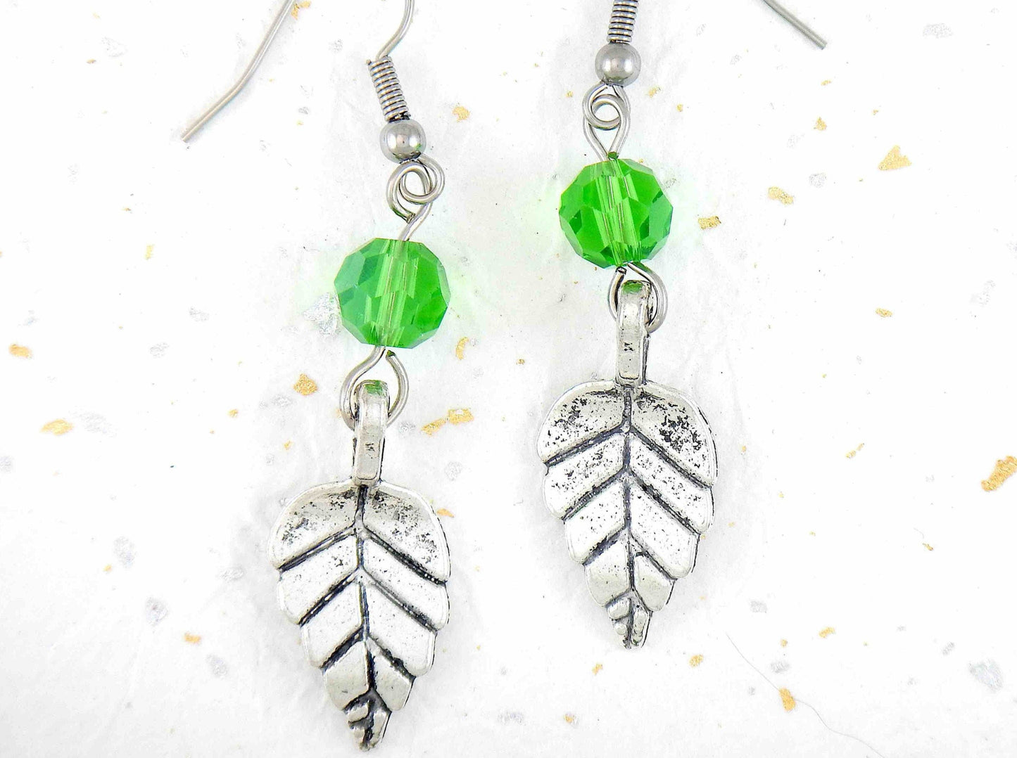 Long earrings with pewter leaves and green faceted crystal balls, stainless steel hooks