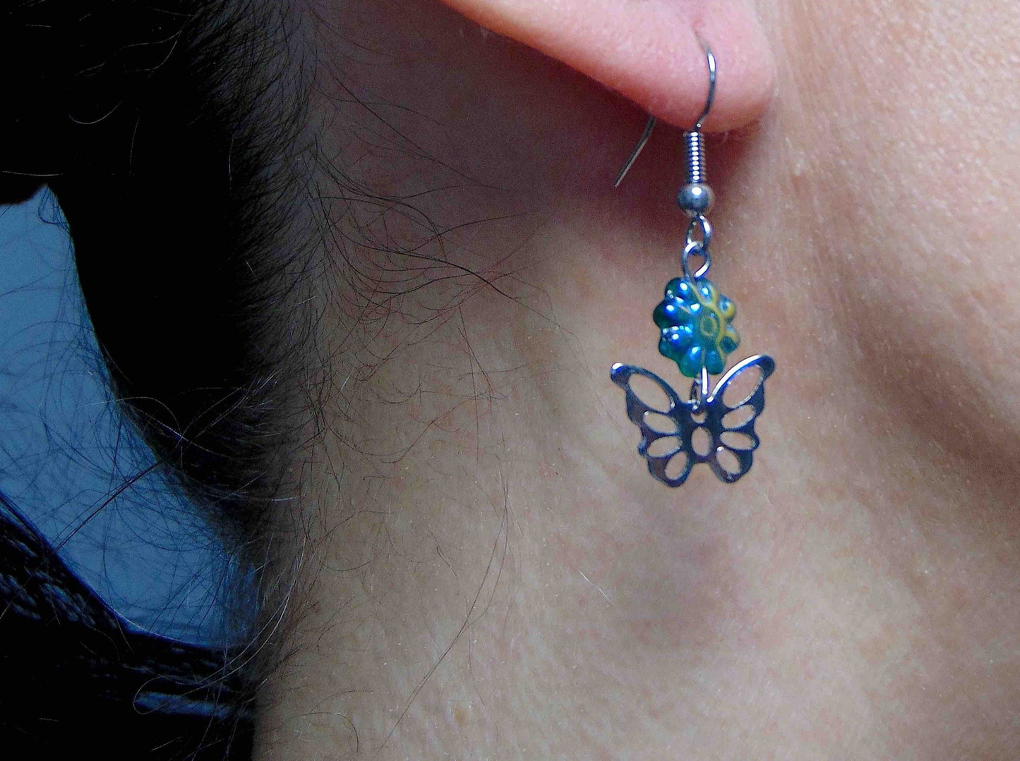 Short earrings with stainless steel butterflies and iridescent green Czech glass flowers, stainless steel hooks