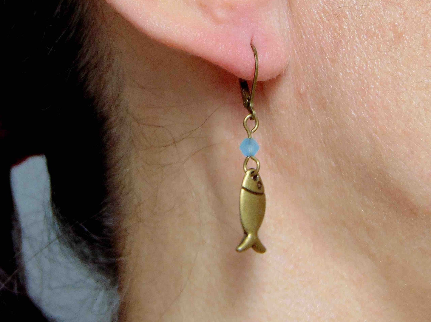 Short earrings with stylized brass fish and bright turquoise Swarovski crystals, brass lever back hooks