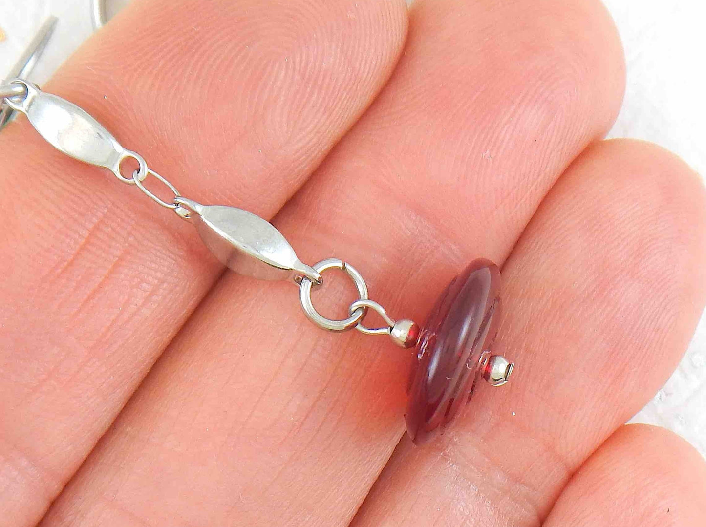 Long earrings with deep red translucent glass disks on stainless steel box-shaped chain and lever back hooks