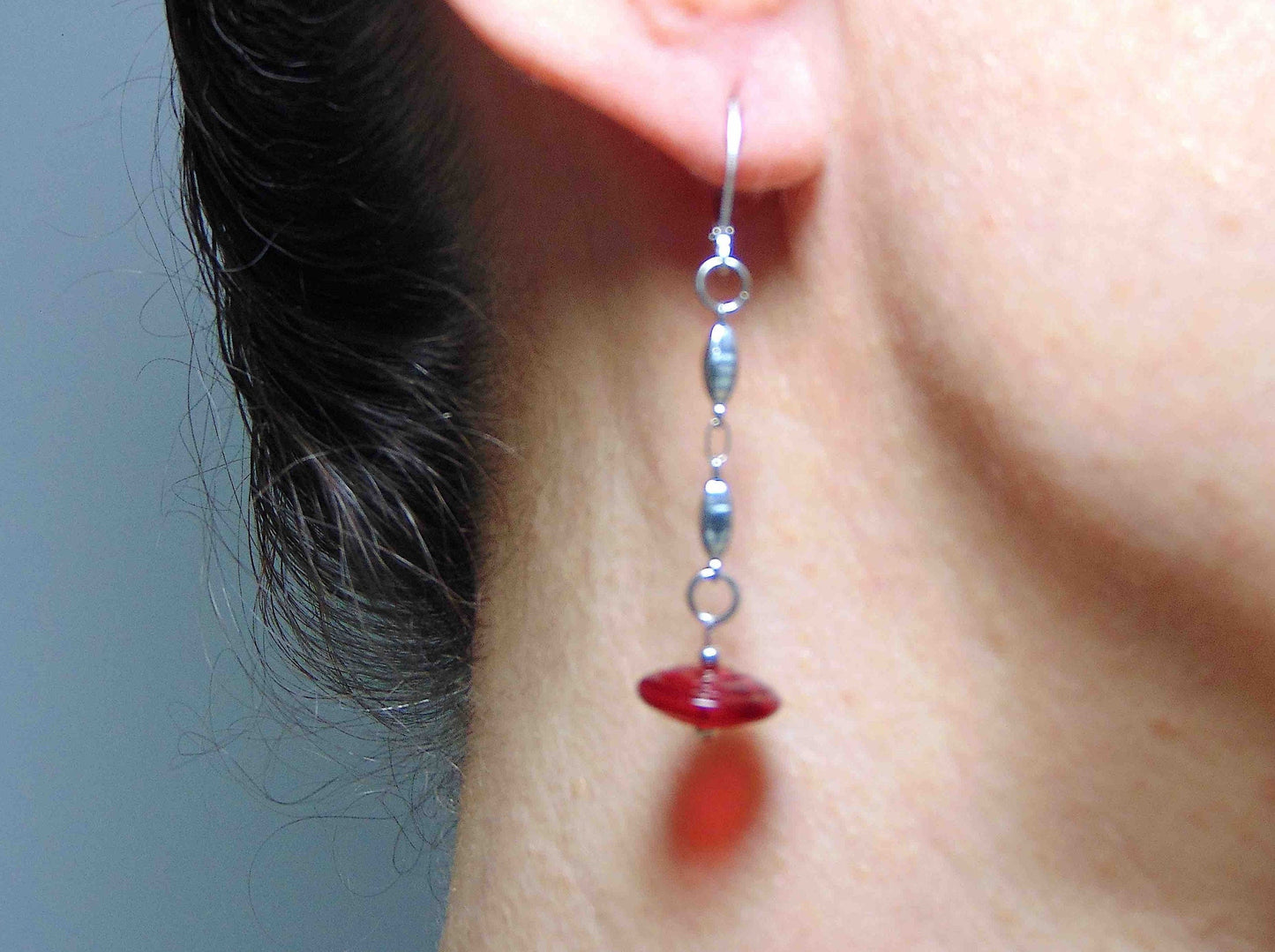 Long earrings with deep red translucent glass disks on stainless steel box-shaped chain and lever back hooks