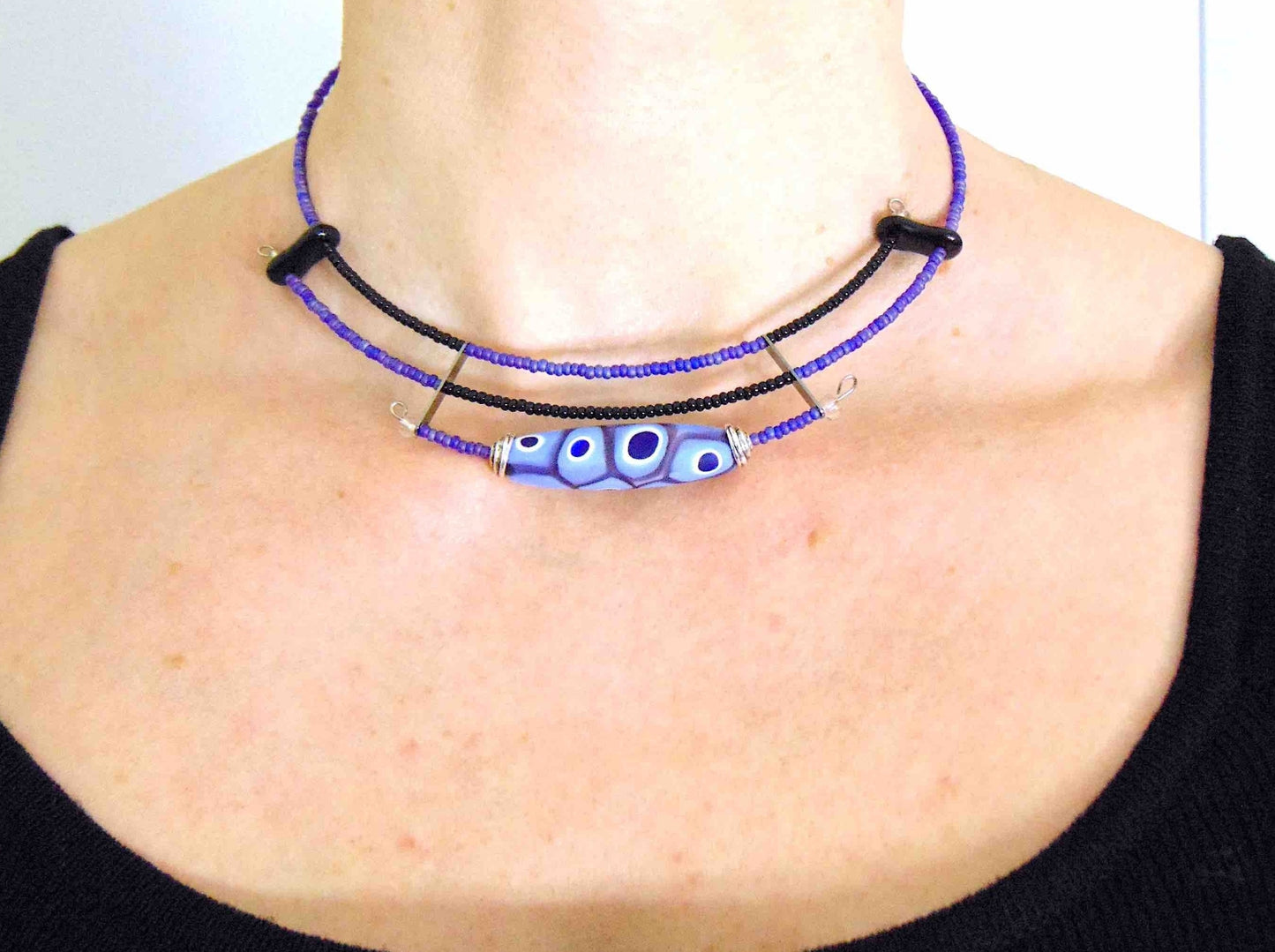 Short asymmetric necklace with matte lilac and black Murano glass bead, eye-dot pattern, metal clasp