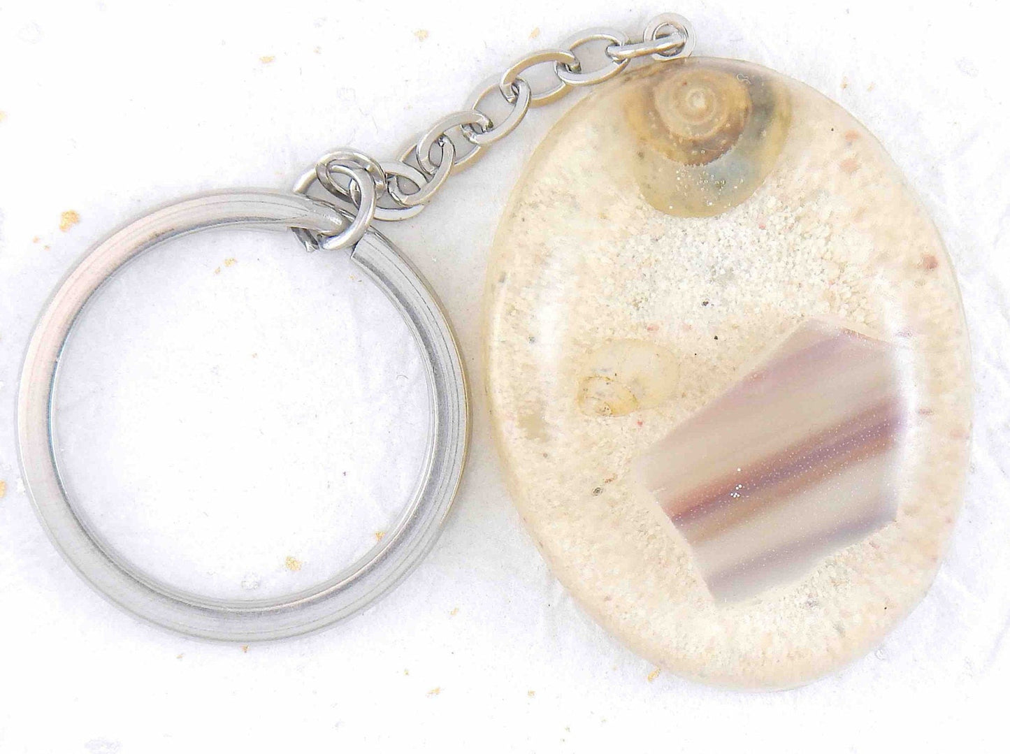 Keychain with handmade resin oval, white beach sand, violet-lilac striped glass and shells, stainless steel chain